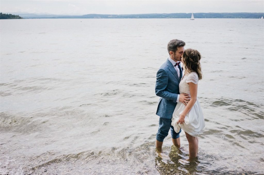hochzeitspaar steht für hochzeitsbilder im ammersee bei herrsching