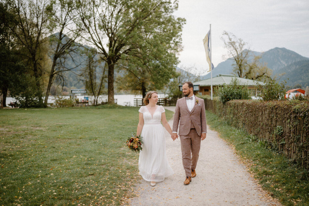 Hochzeitspaar läuft am Strand zur standesamtlichen Hochzeit in Schliersee Rathaus