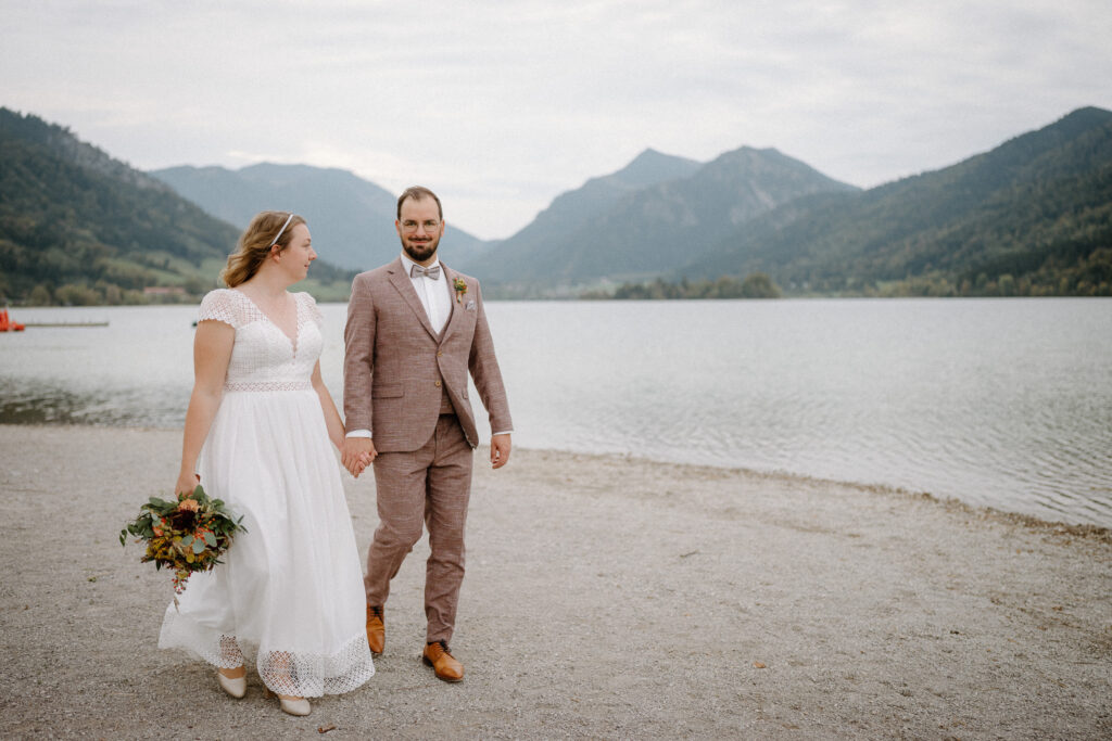 Hochzeitspaar läuft am Strand zur Hochzeit in Schliersee Rathaus